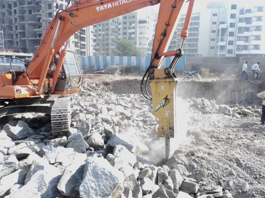 Excavator with a hydraulic rock breaker working through sandstone